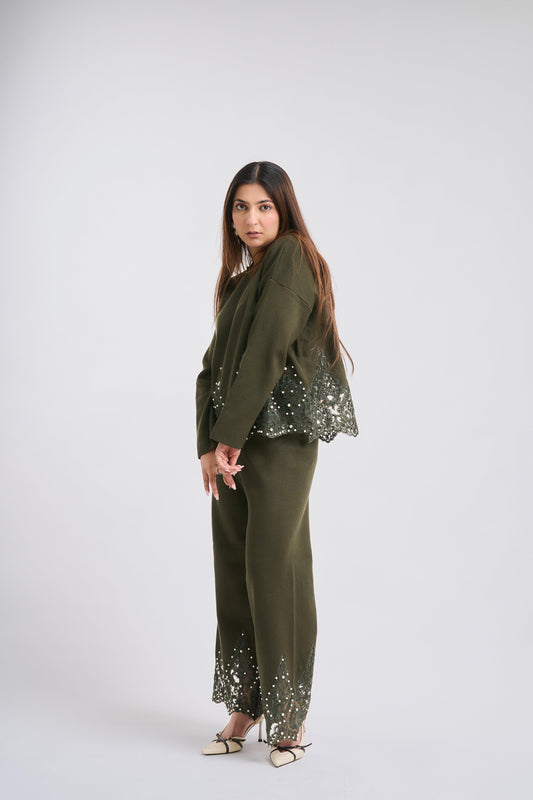 Woman wearing a green outfit with sequin details on a white background