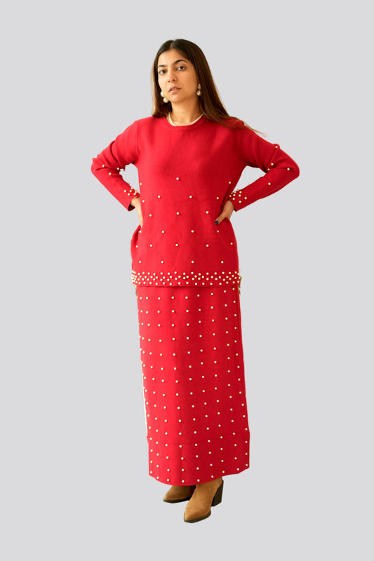 Woman wearing a red dress with white polka dots on a light gray background
