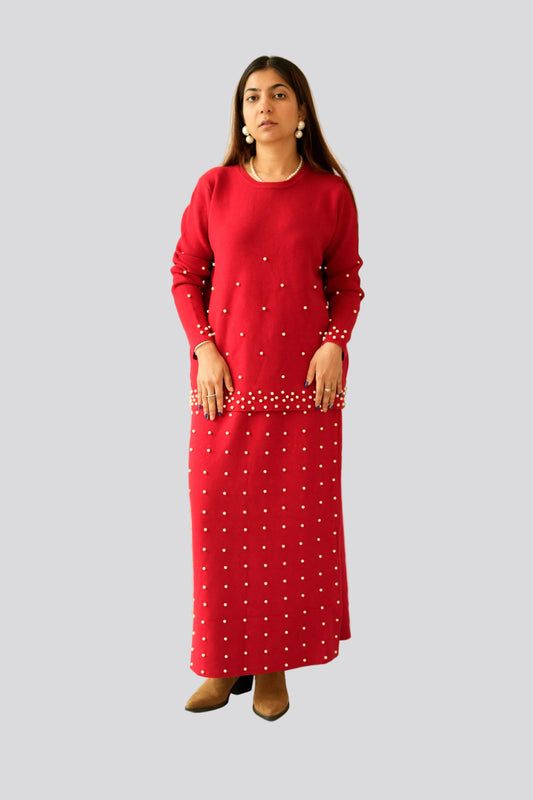 Woman wearing a red dress with white polka dots on a light gray background