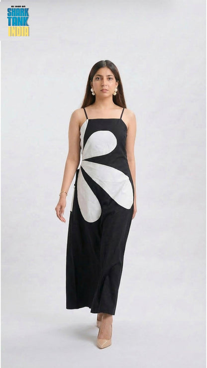 Woman wearing a black dress with a white floral design on a white background