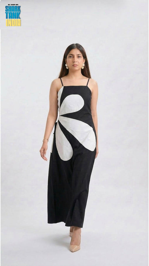 Woman wearing a black dress with a white floral design on a white background