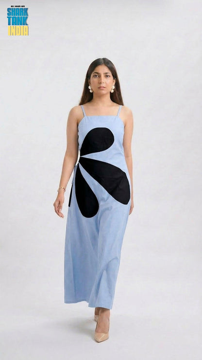 Woman wearing a light blue dress with black abstract design on a white background
