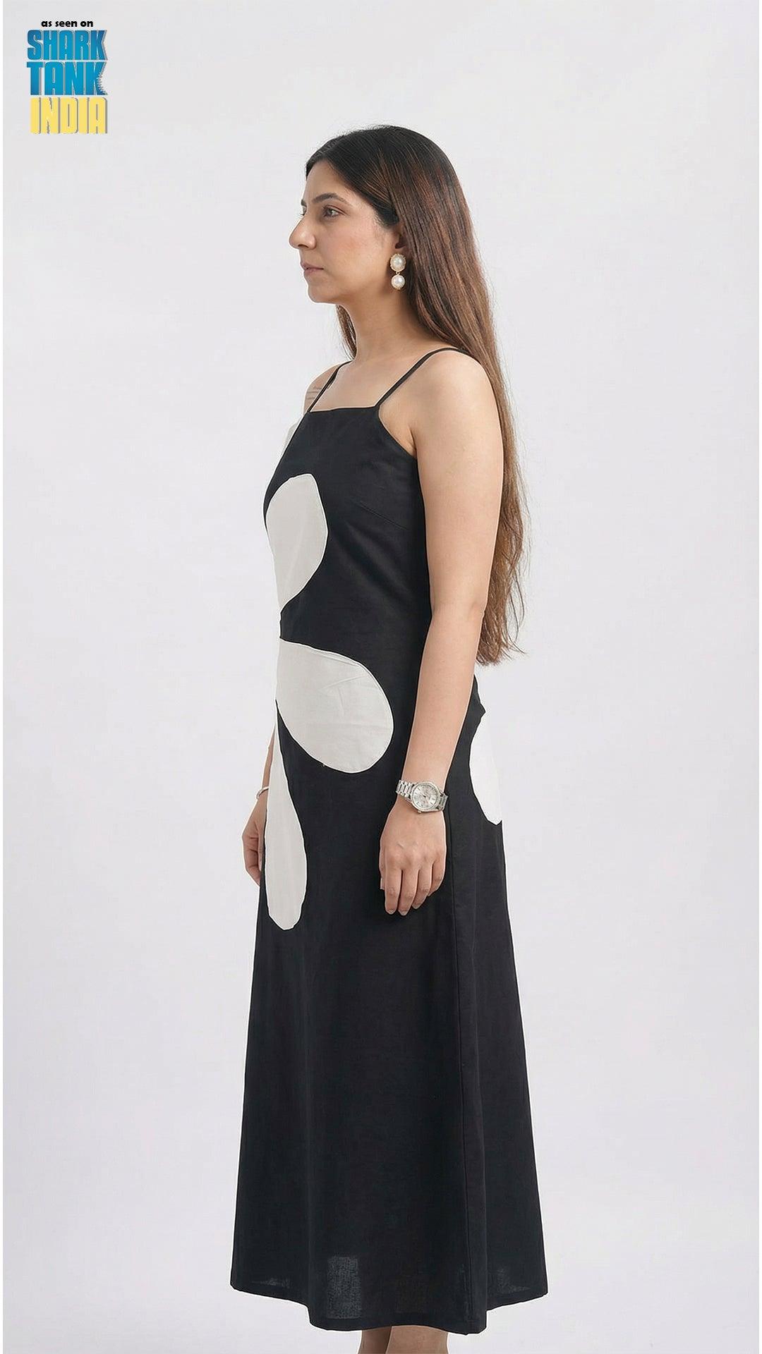 Woman wearing a black dress with white circular patterns on a white background