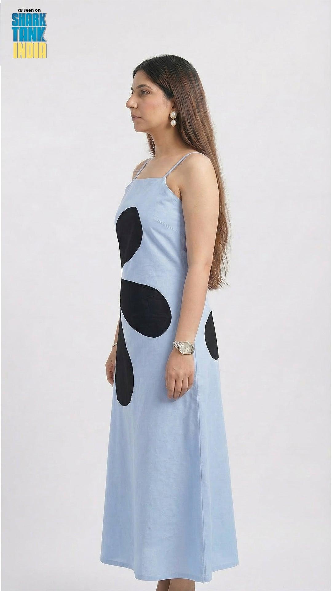 Woman wearing a light blue dress with black polka dots on a white background