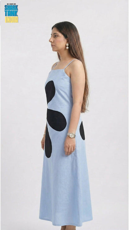 Woman wearing a light blue dress with black polka dots on a white background