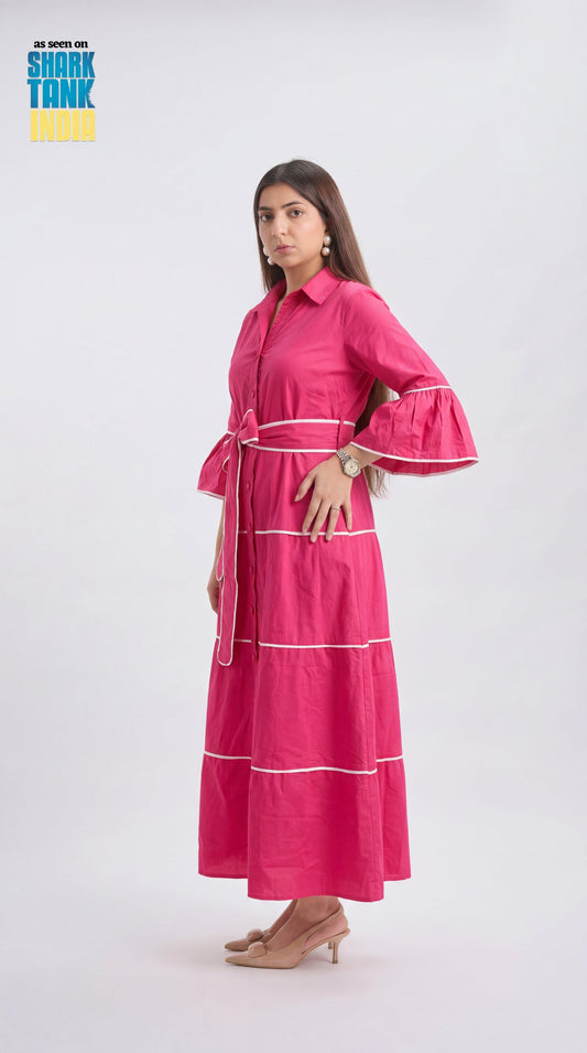 Woman wearing a pink dress with ruffled sleeves on a white background