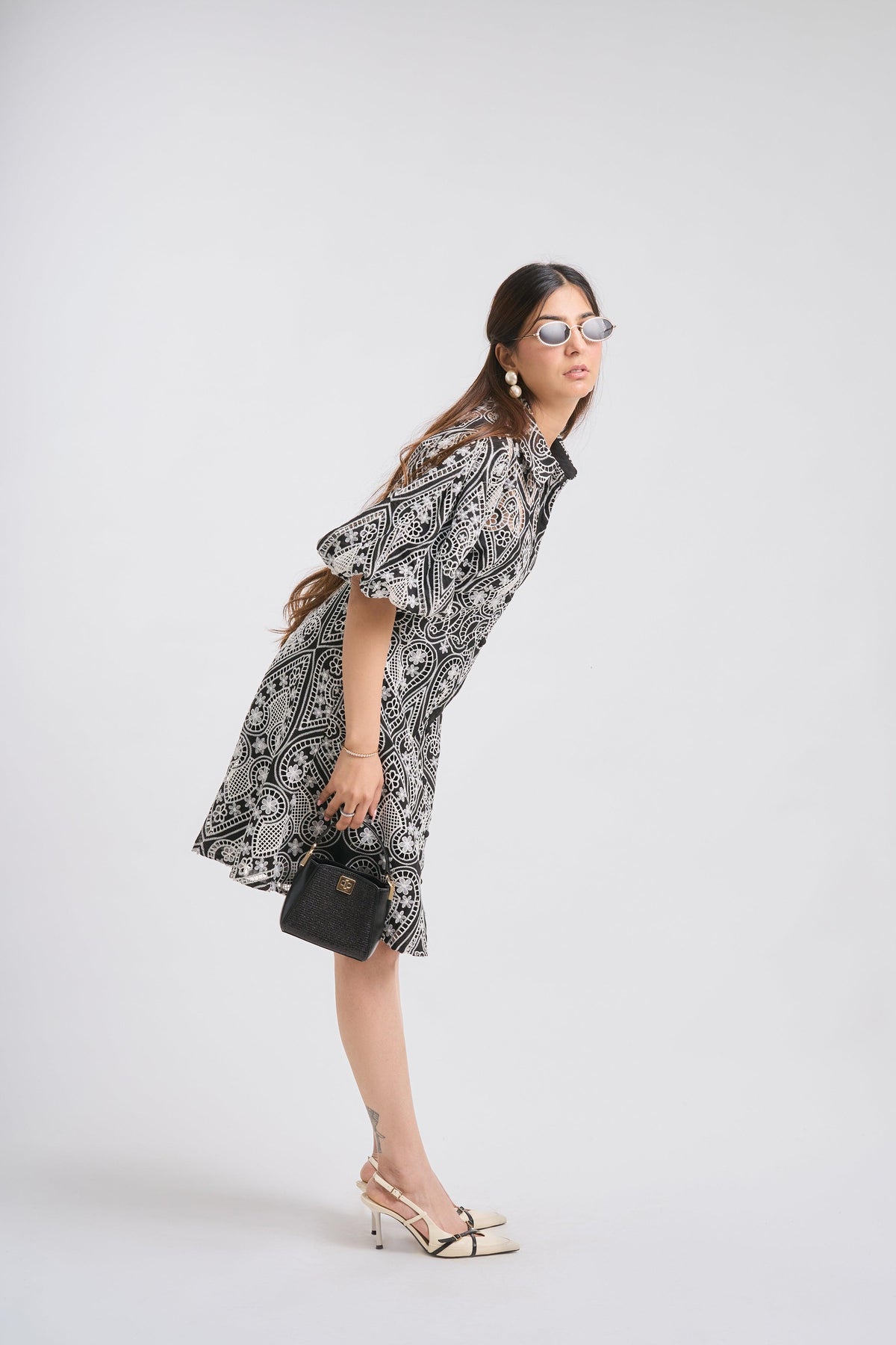 Woman wearing a black and white patterned dress on a white background