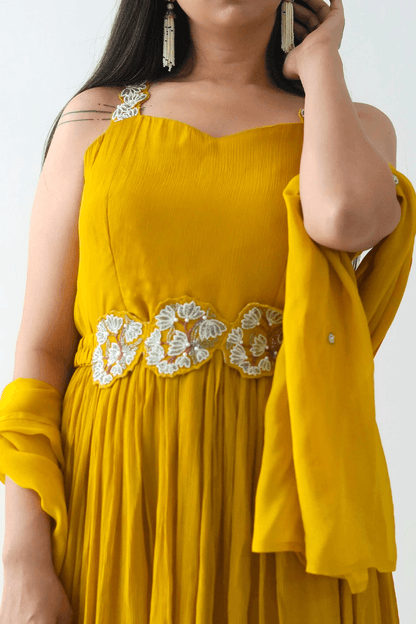 Yellow dress with floral embroidery on a plain background