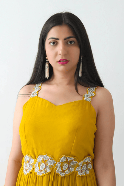 Woman wearing a yellow dress with white embroidery on a white background