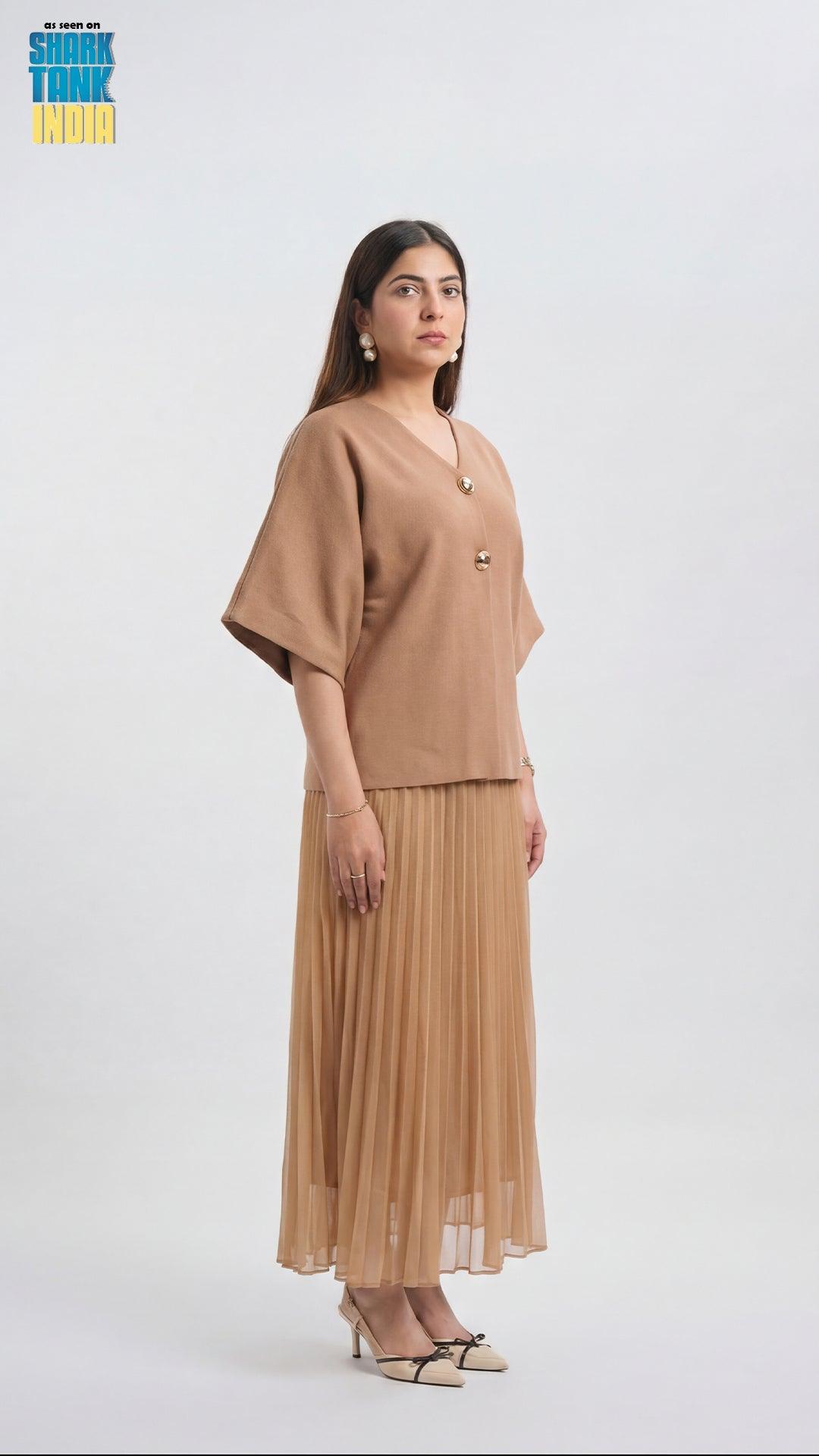 Woman wearing a beige outfit with a plain background