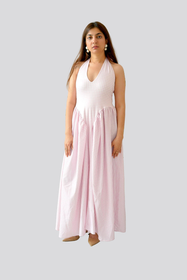 Woman wearing a white and pink checkered dress on a gray background