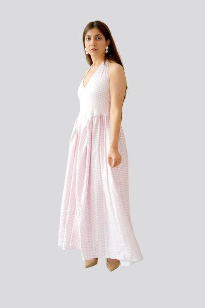 Woman wearing a white and pink checkered dress on a light gray background