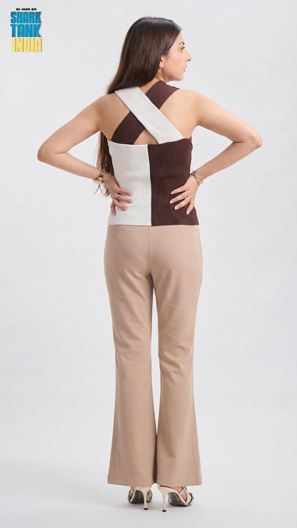 Woman wearing a two-tone jumpsuit with a white and brown color scheme on a plain background.