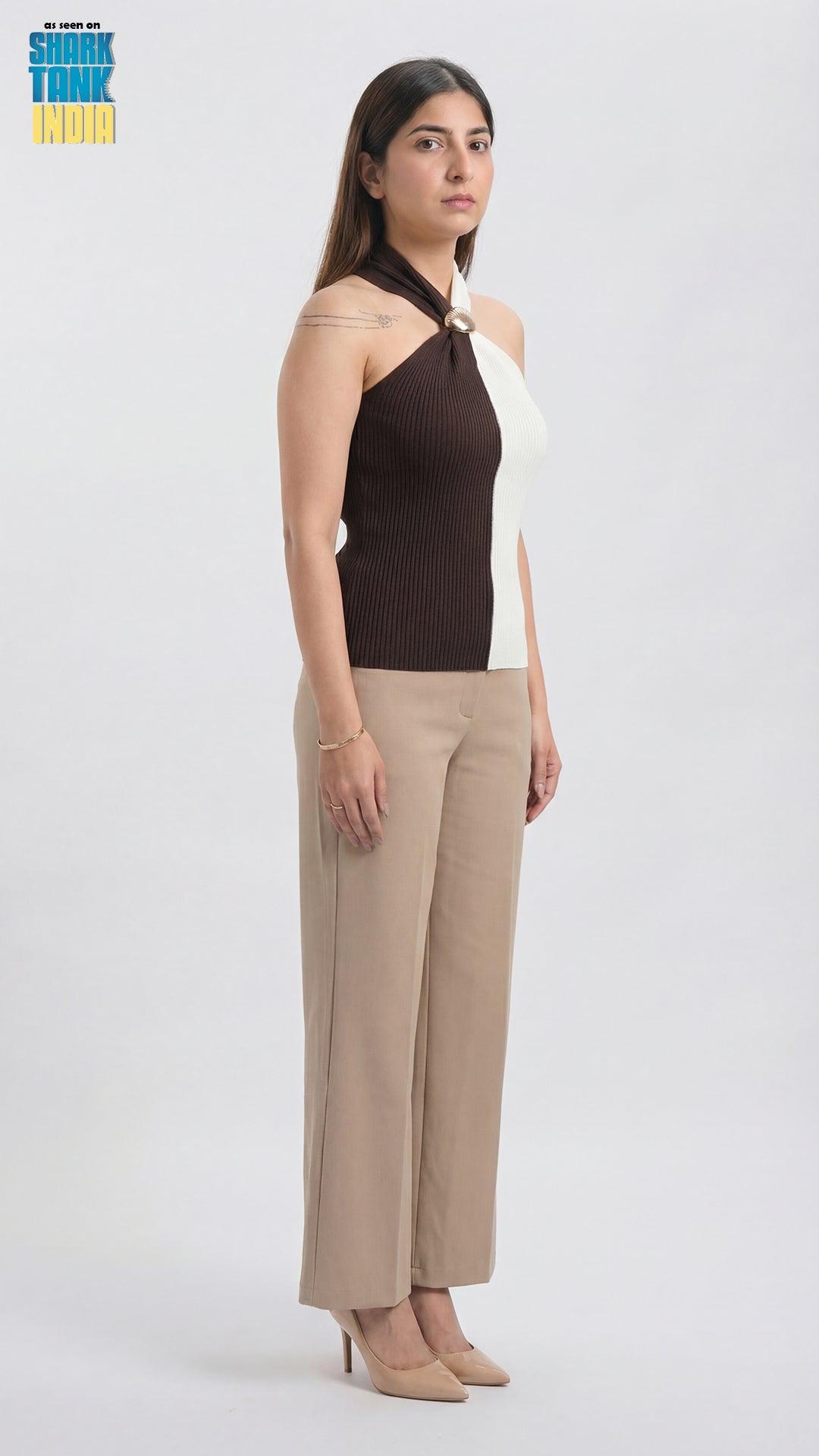 Woman wearing a black and white top with beige pants on a white background