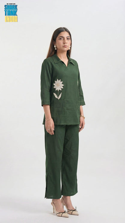 Woman wearing a green outfit with floral details on a white background