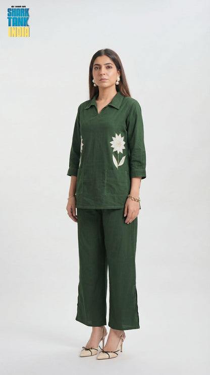 Woman wearing a green outfit with floral design on a white background