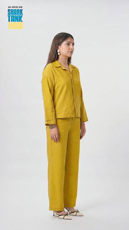 Woman wearing a mustard yellow outfit on a white background with 'Shark Tank' branding.