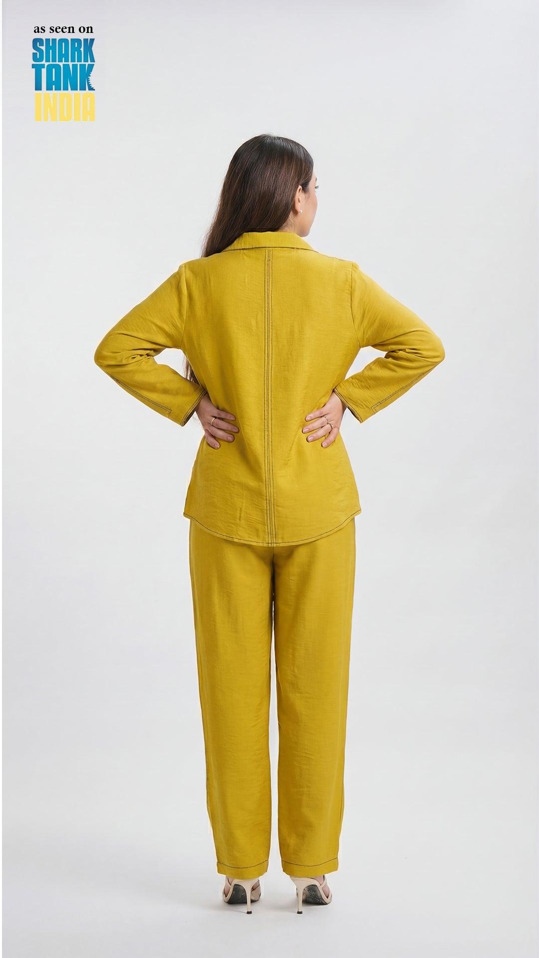 Woman wearing a mustard yellow outfit on a white background with 'Shark Tank' branding.