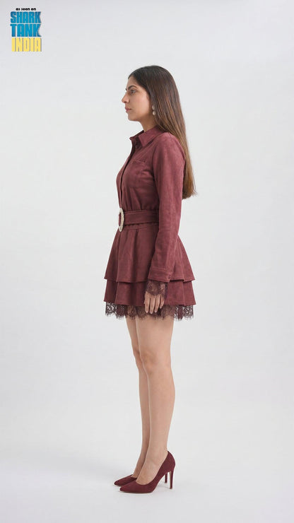 Woman wearing a burgundy dress with lace details on a white background