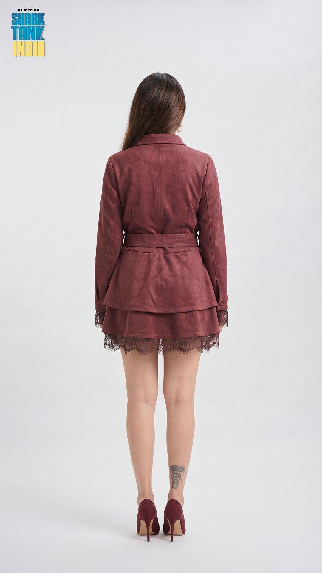 Woman wearing a burgundy dress with a belt on a white background