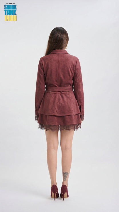 Woman wearing a burgundy dress with a belt on a white background