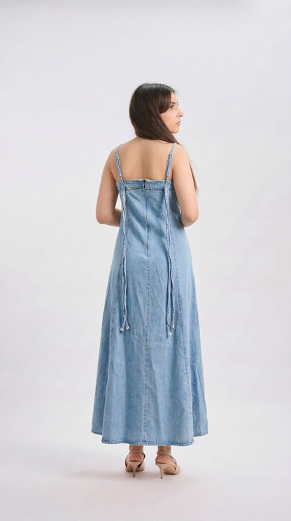 Woman wearing a light blue denim dress on a white background