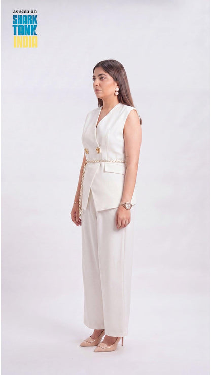 Woman wearing a white sleeveless blazer and pants on a white background with 'Shark Tank' branding.