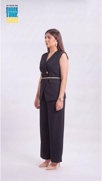 Woman wearing a black outfit with gold accents on a white background