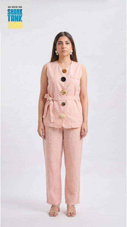 Woman wearing a pink outfit with buttons on a white background