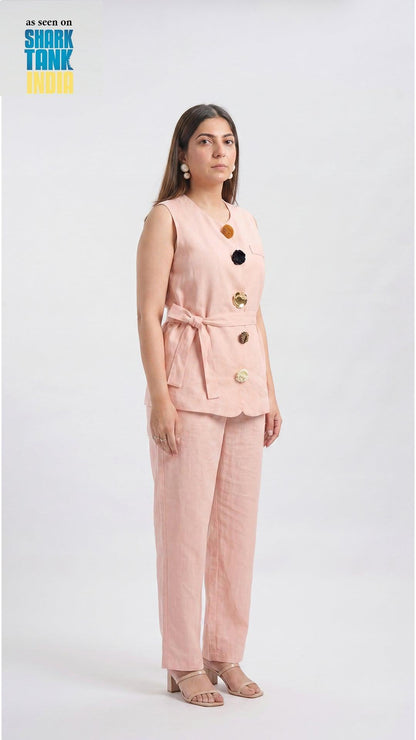 Woman wearing a pink suit with gold buttons on a white background