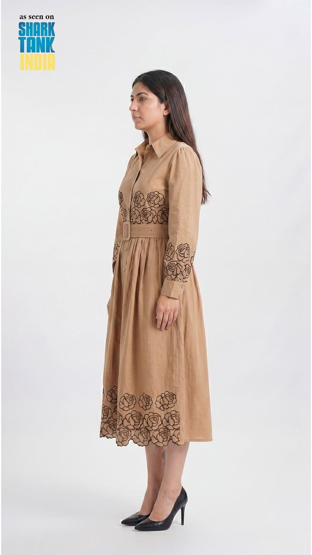 Woman wearing a beige dress with floral embroidery on a white background