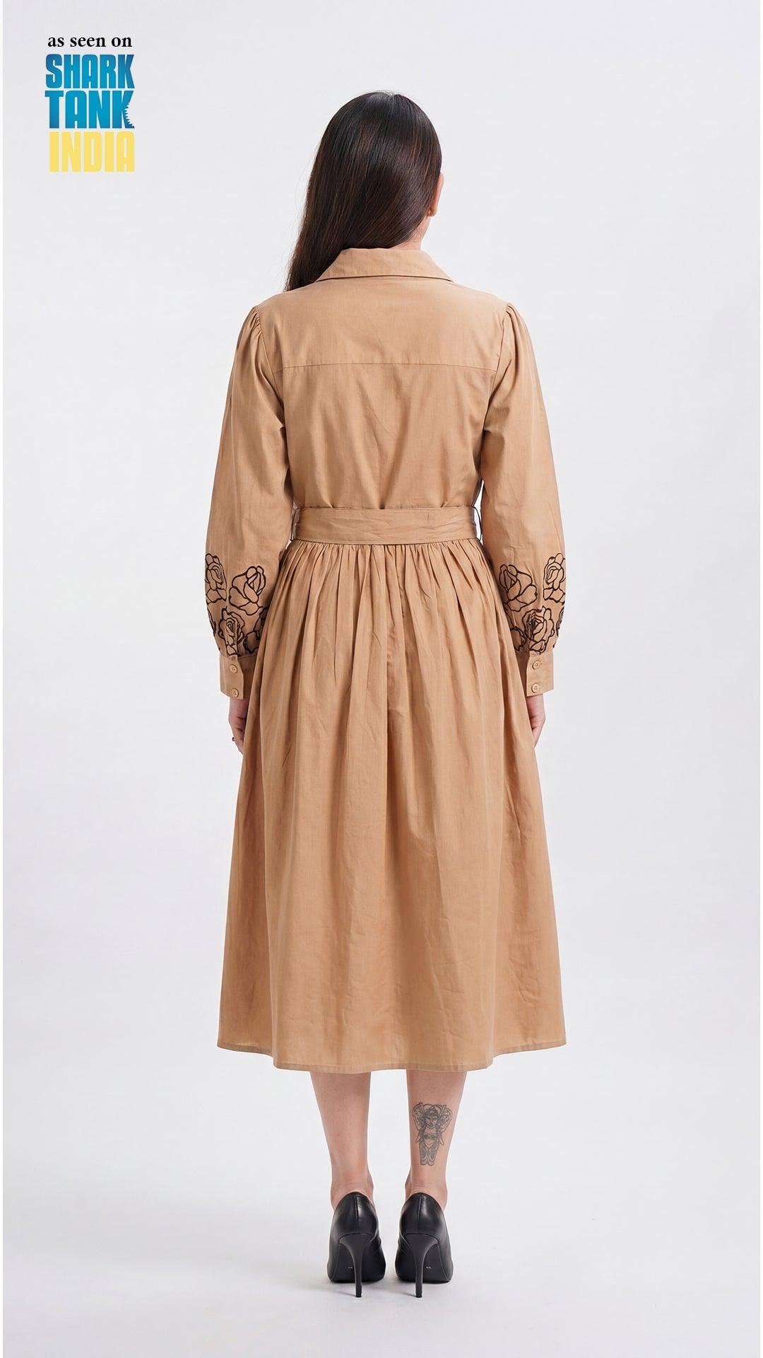 Woman wearing a tan dress with lace sleeves on a white background, featuring Shark Tank branding.