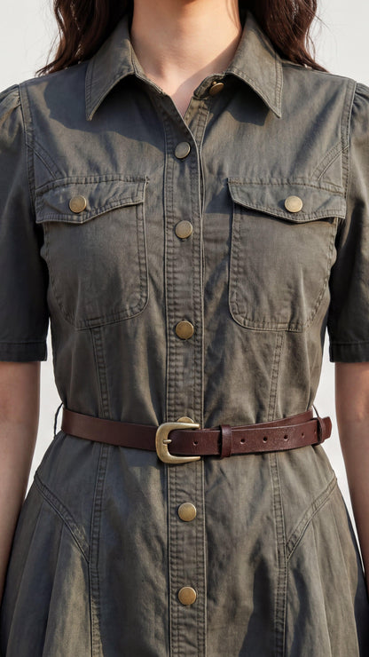 Green denim dress with brown belt on a neutral background