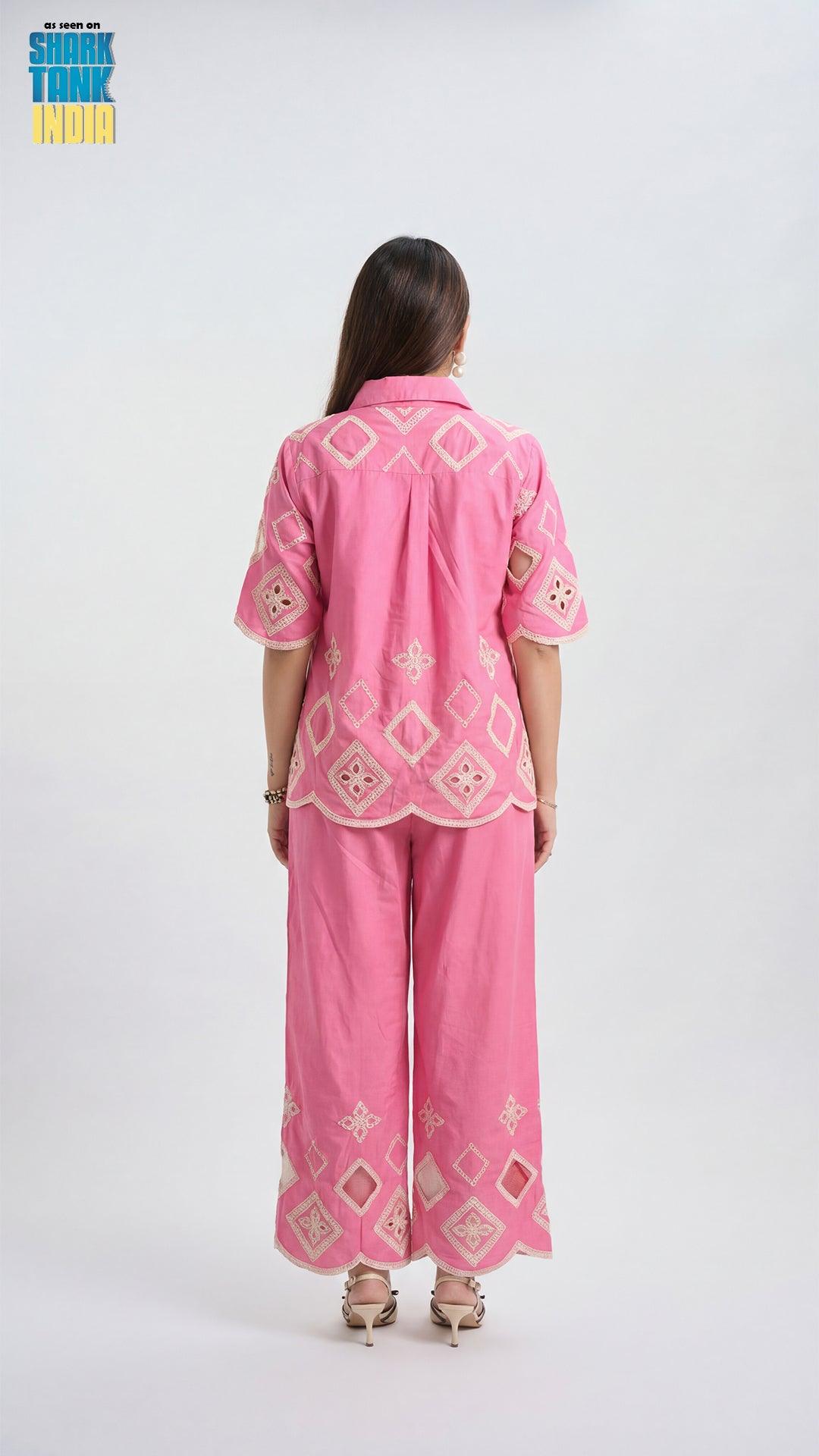 Woman wearing a pink embroidered outfit on a white background