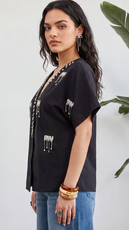 Woman wearing a black top with decorative elements against a white background