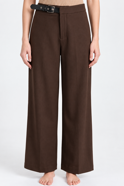 A model wearing dark brown wide-leg trousers with a black belt, shown from the waist down against a plain white studio background.