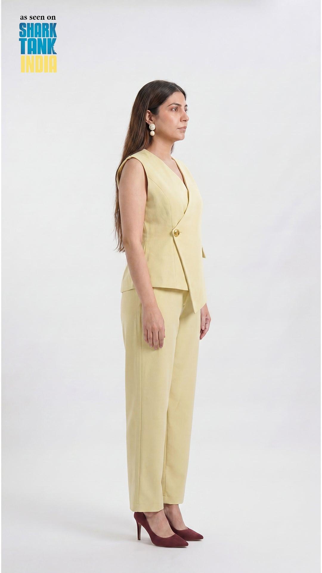 Woman wearing a light yellow suit standing against a white background