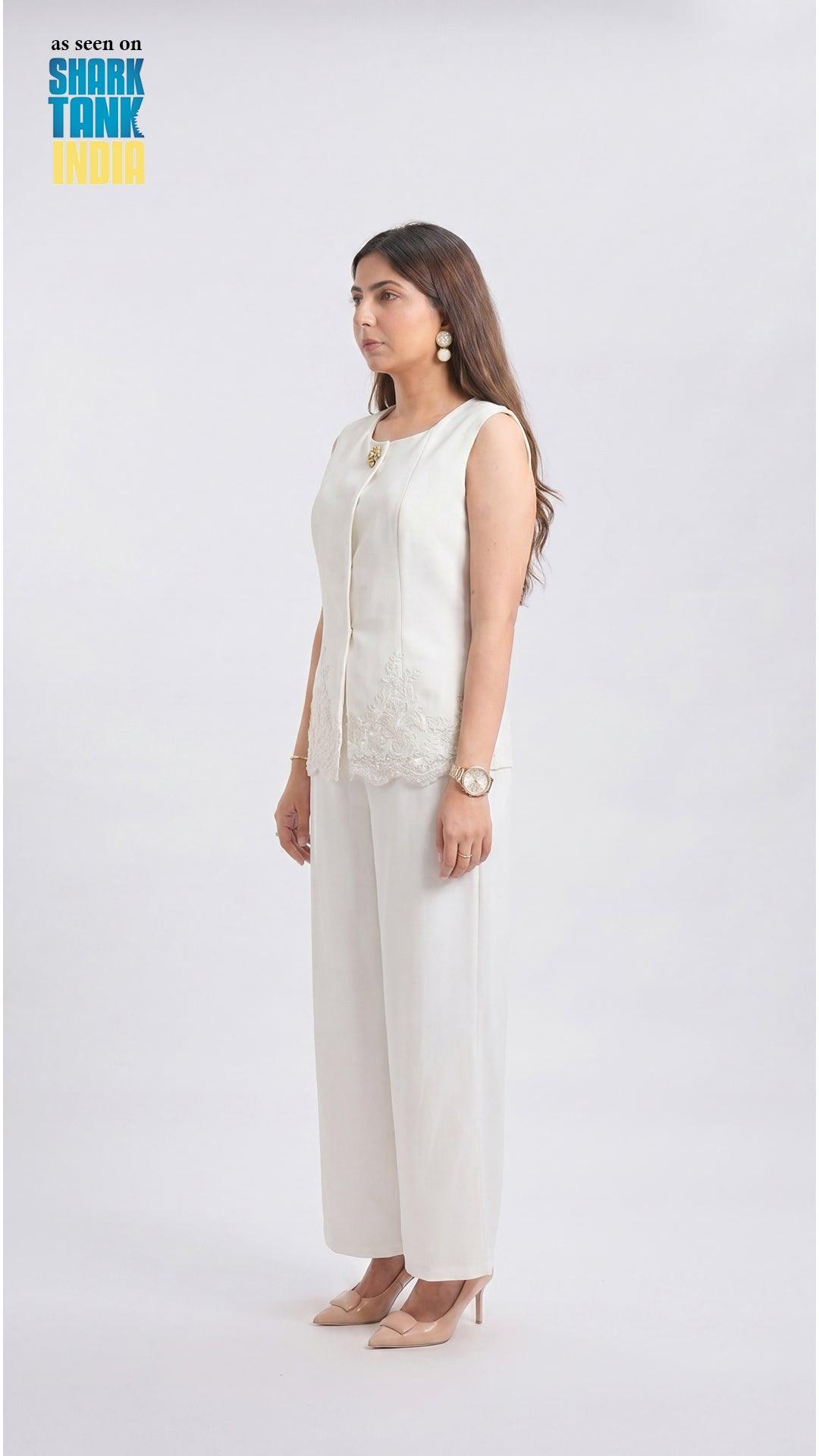 Woman wearing a white outfit on a plain background with 'Shark Tank India' branding.
