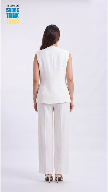 Woman wearing a white sleeveless top and pants on a white background with 'Shark Tank' branding.
