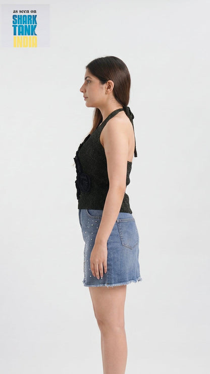 Woman wearing a black sleeveless top and denim skirt on a white background with 'Shark Tank' branding.