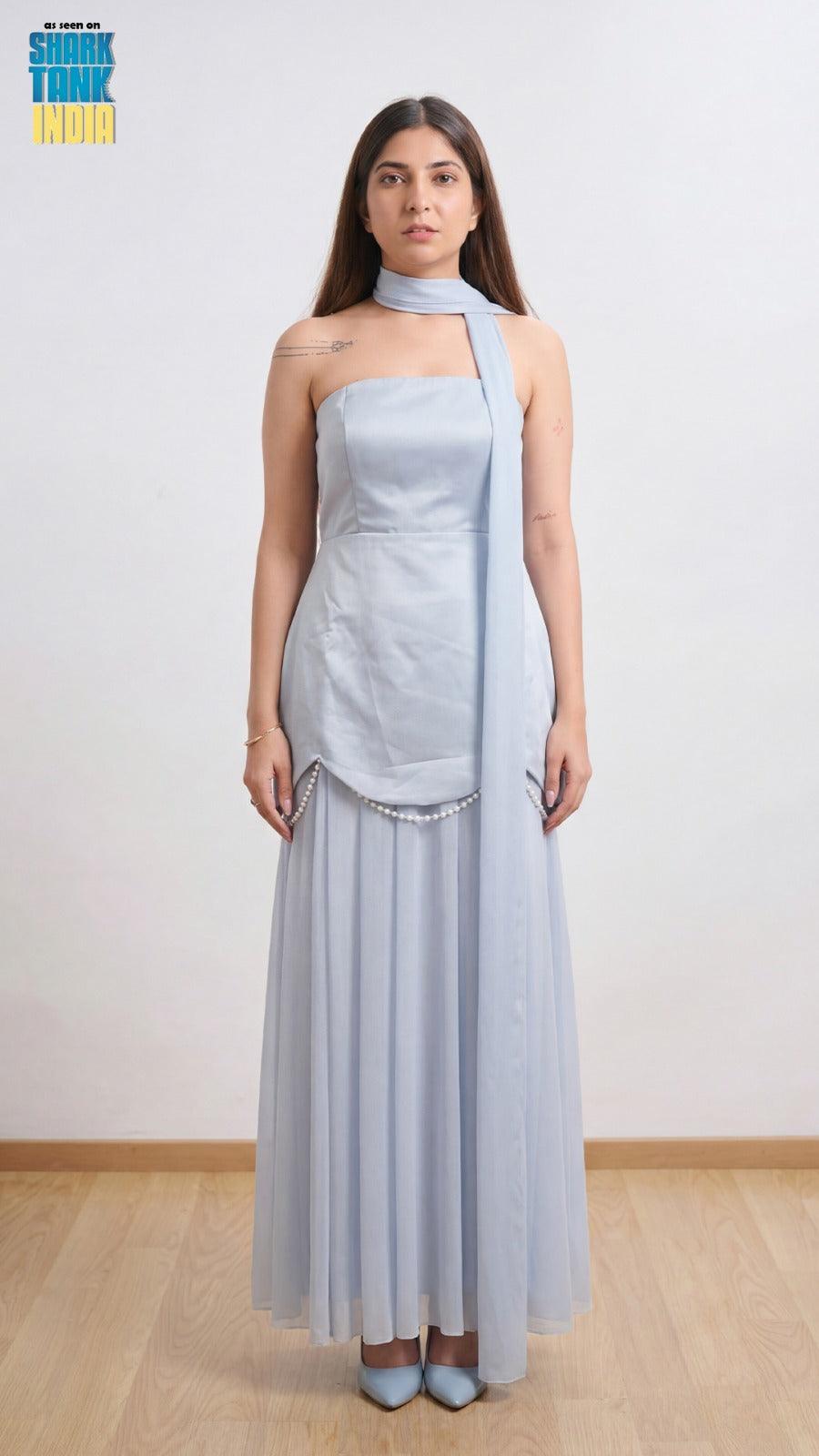 Woman wearing a light blue strapless dress with a matching shawl against a white background