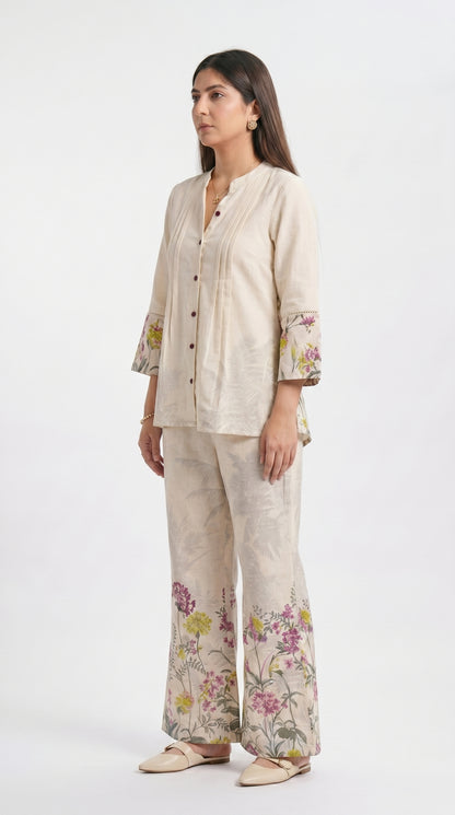 Woman wearing a beige outfit with floral patterns on a white background
