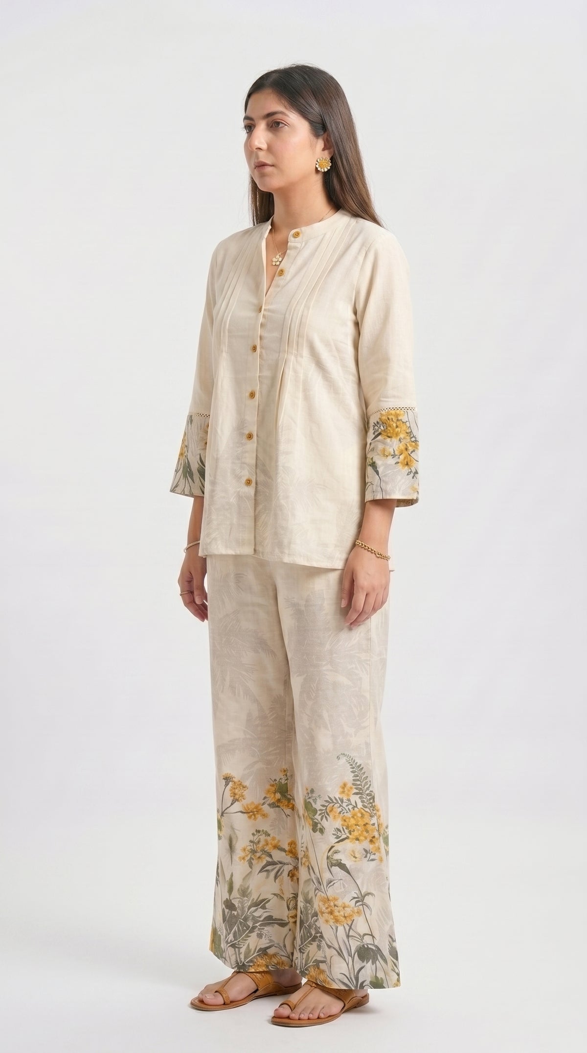 Woman wearing a beige outfit with floral patterns on a white background