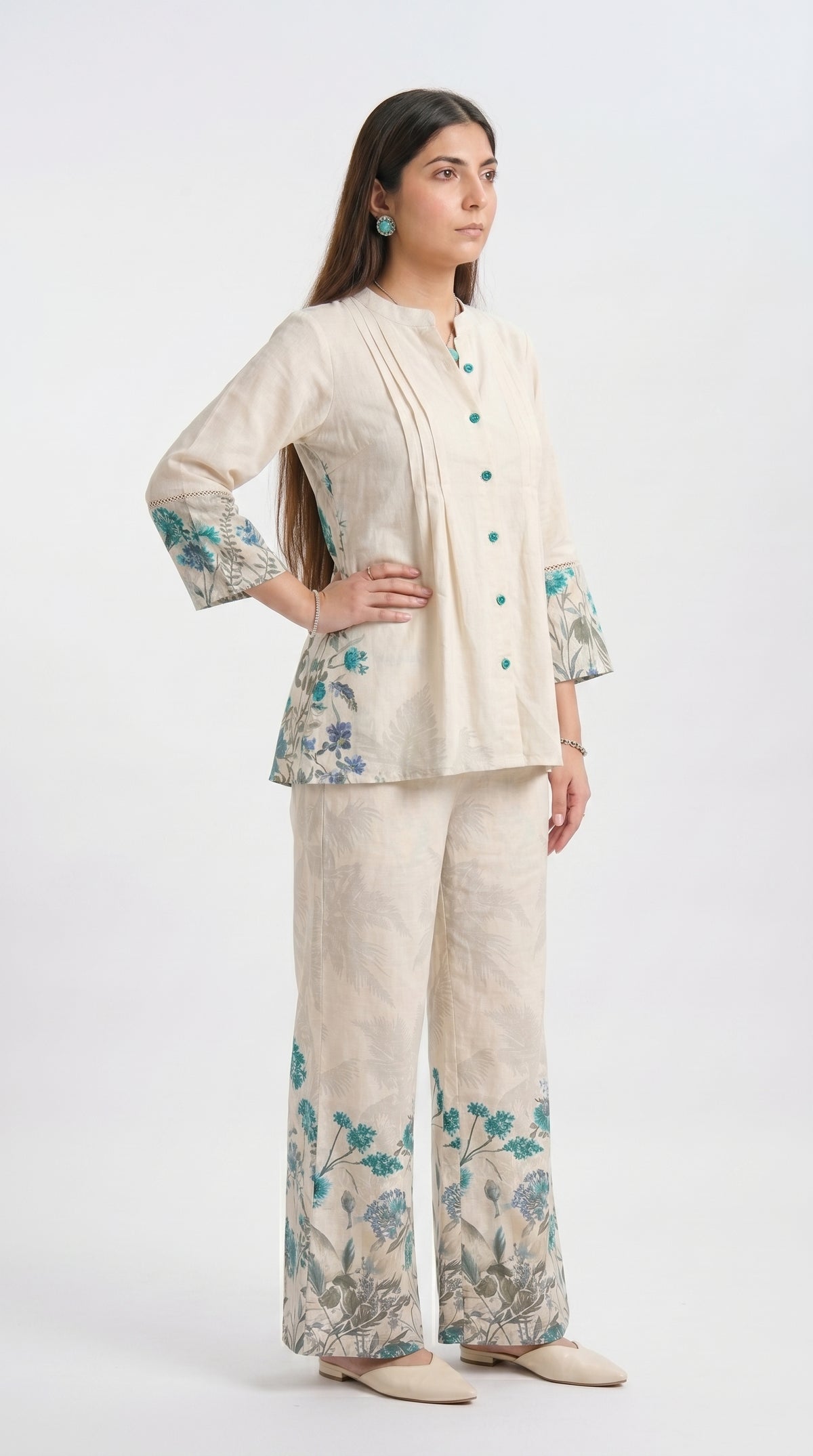 Woman wearing a cream outfit with floral patterns on a white background