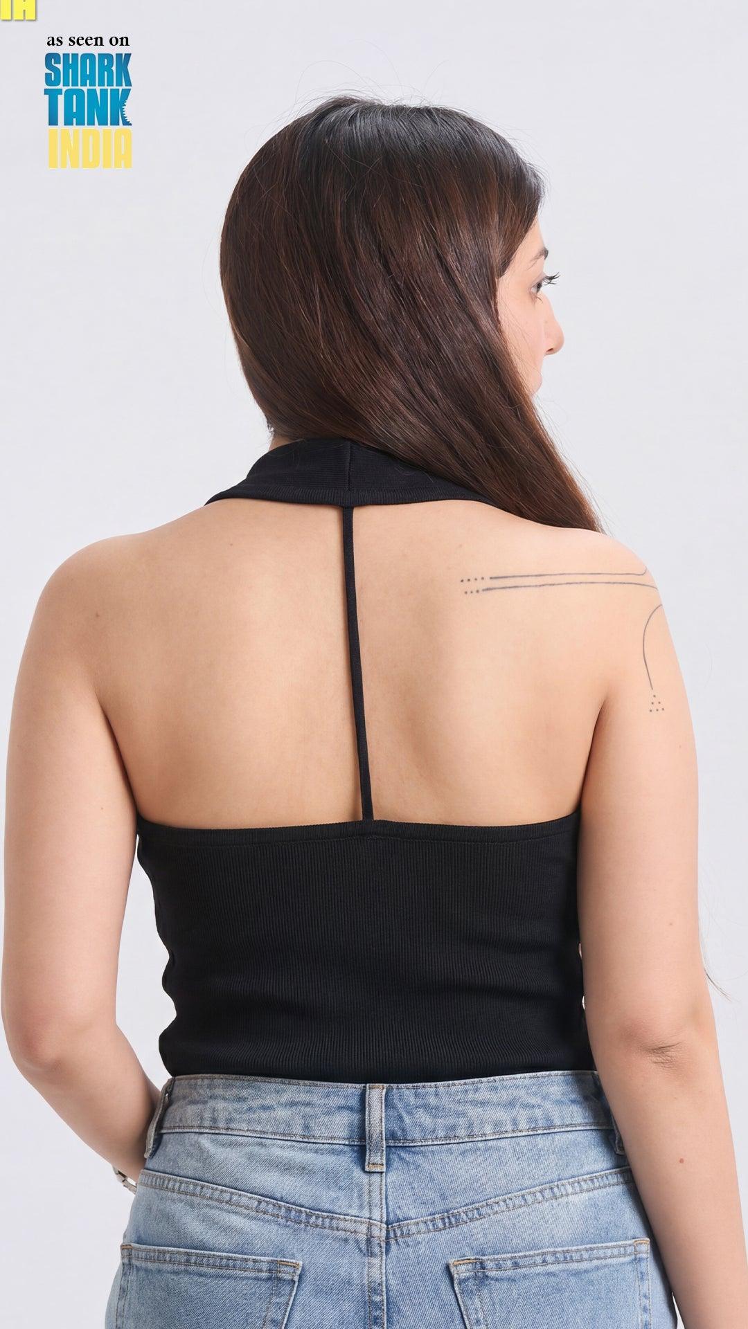 Person wearing a black halter top and blue jeans on a white background