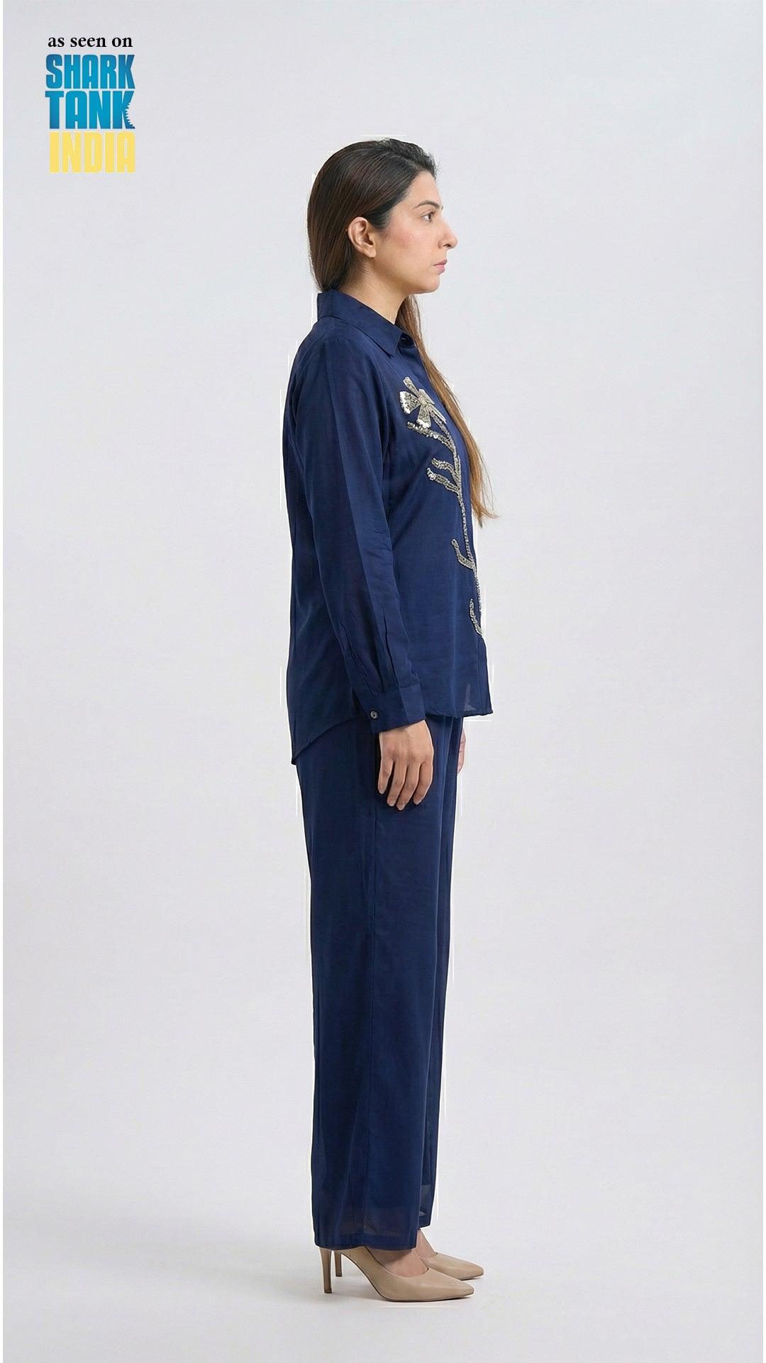 Woman wearing a navy blue outfit with floral patterns on a white background