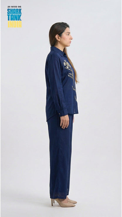Woman wearing a navy blue outfit with floral patterns on a white background