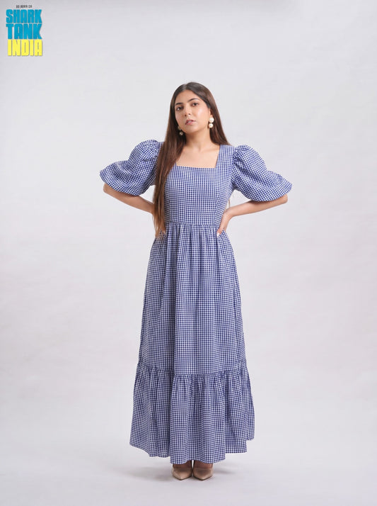 Woman wearing a blue checkered dress with puff sleeves on a white background