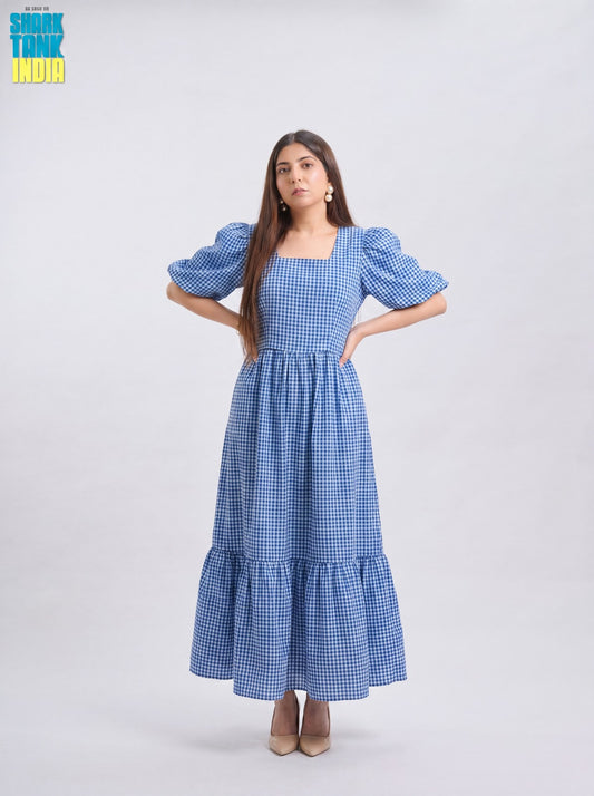 Woman wearing a blue checkered dress with puffed sleeves on a white background