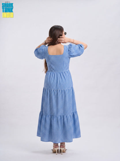 Woman wearing a blue checkered dress with a plain background